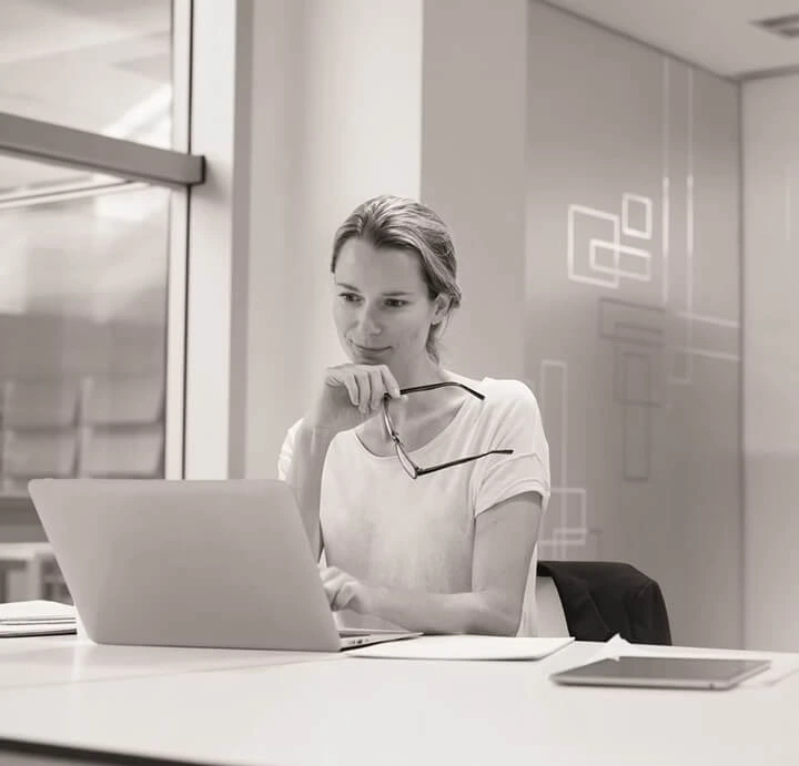 Frau arbeitet konzentriert am Laptop.